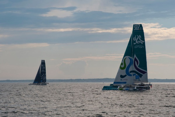 MOD70 trimarans racing out the Newport channel.